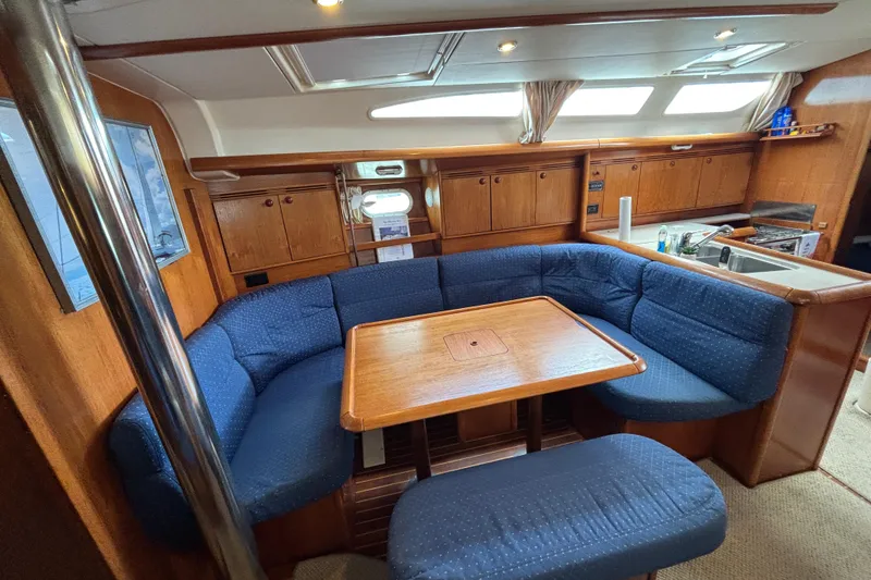 Slide: The Image of Interior of 2004 Jeanneau Sun Odyssey 40.3 sailboat with cozy seating and wooden cabinetry. - 28