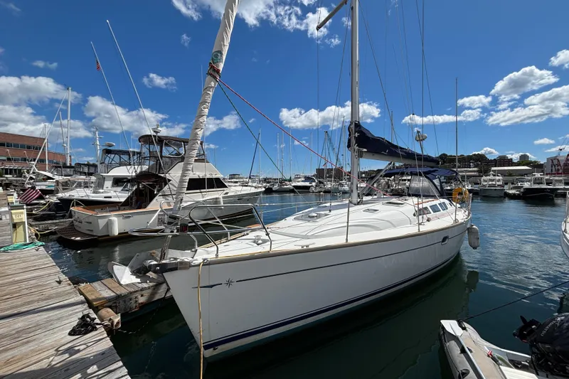 Slide: The Image of 2004 Jeanneau Sun Odyssey 40.3 sailboat docked in a marina under a clear blue sky. - 3