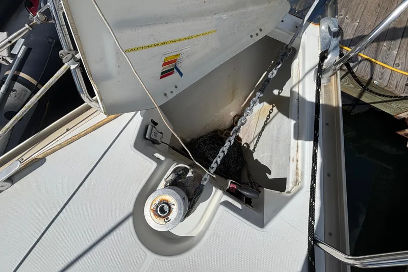 Slide: The Image of Anchor chain and windlass on 2004 Jeanneau Sun Odyssey 40.3 sailboat deck. - 40