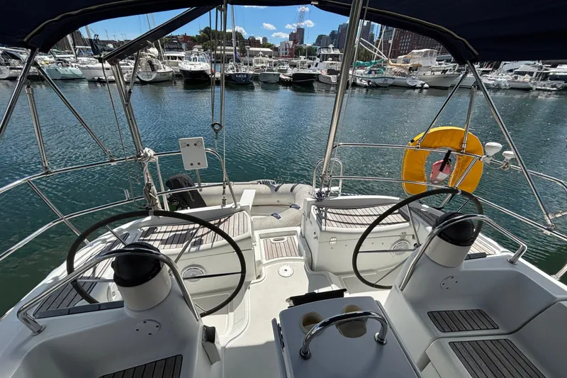 Slide: The Image of 2004 Jeanneau Sun Odyssey 40.3 sailboat cockpit with dual steering wheels in marina. - 7