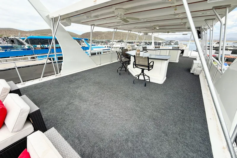Slide: The Image of Luxurious 2008 Sumerset houseboat deck with seating and bar area, docked at marina. - 23