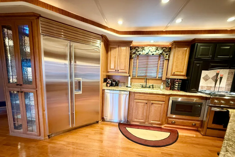 Slide: The Image of Luxurious kitchen interior of 2008 Sumerset HouseBoat, featuring modern appliances and elegant wood cabinetry. - 38