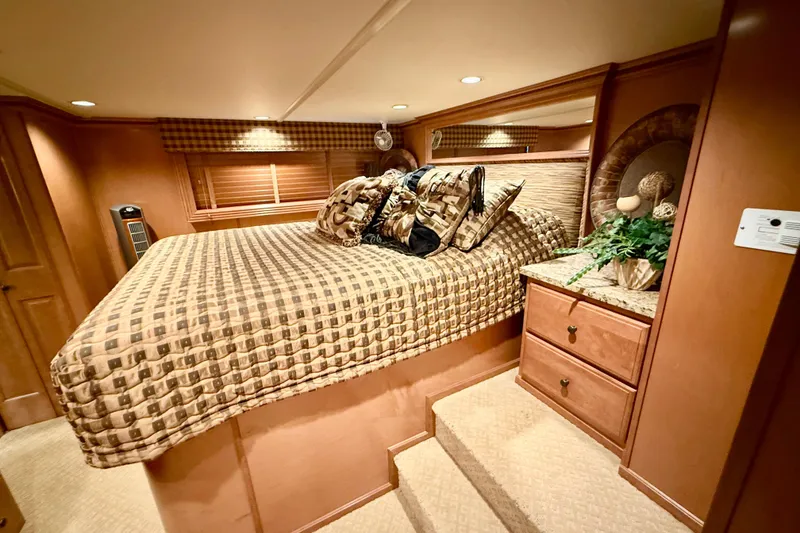 Slide: The Image of Luxurious bedroom interior of 2008 Sumerset HouseBoat, featuring elegant bedding and wooden cabinetry. - 50