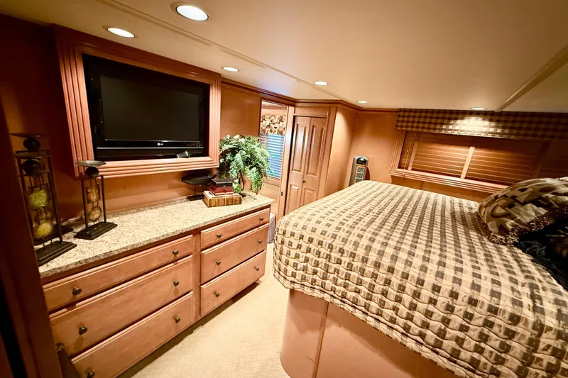 Slide: The Image of Luxurious 2008 Sumerset houseboat bedroom with TV, wooden cabinetry, and cozy bed. - 51