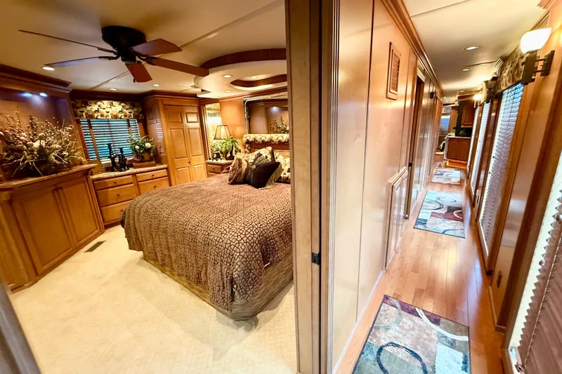 Slide: The Image of Luxurious 2008 Sumerset houseboat interior with elegant bedroom and hallway, featuring wood finishes. - 68