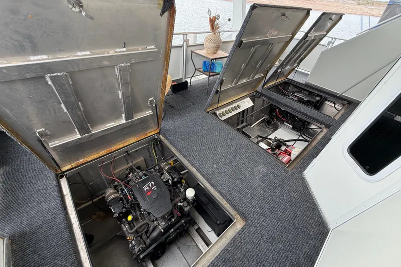 Slide: The Image of Engine compartment of a 2008 Sumerset Luxury HouseBoat, showcasing mechanical components and carpeted flooring. - 86