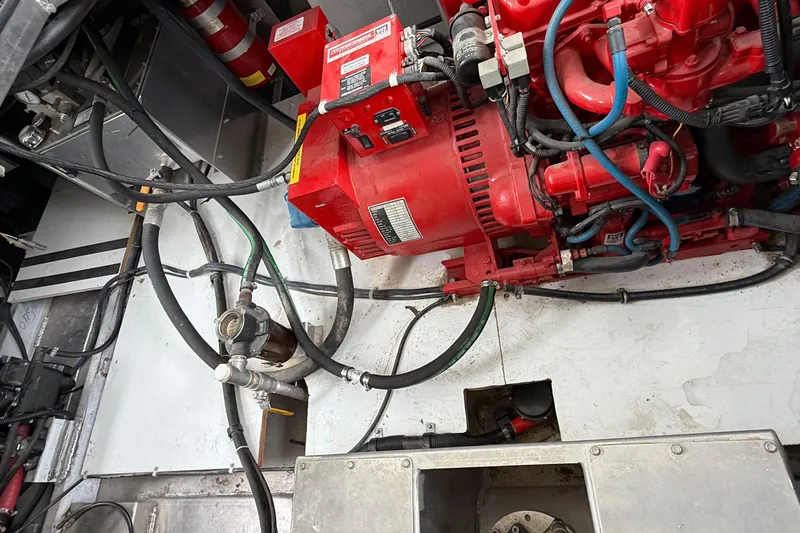 Slide: The Image of Engine room of a 2008 Sumerset Luxury HouseBoat, featuring red machinery and various cables. - 90