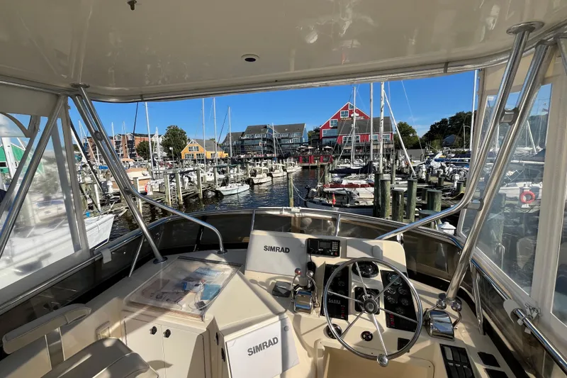Slide: The Image of 2006 Sabre 36 Flybridge Sedan helm view overlooking marina with colorful buildings and boats. - 12