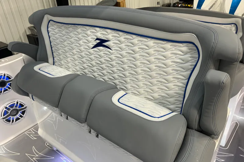 Slide: The Image of 2024 Donzi 39 VRZ boat interior with luxurious gray and white seating and chrome steering wheel. - 36