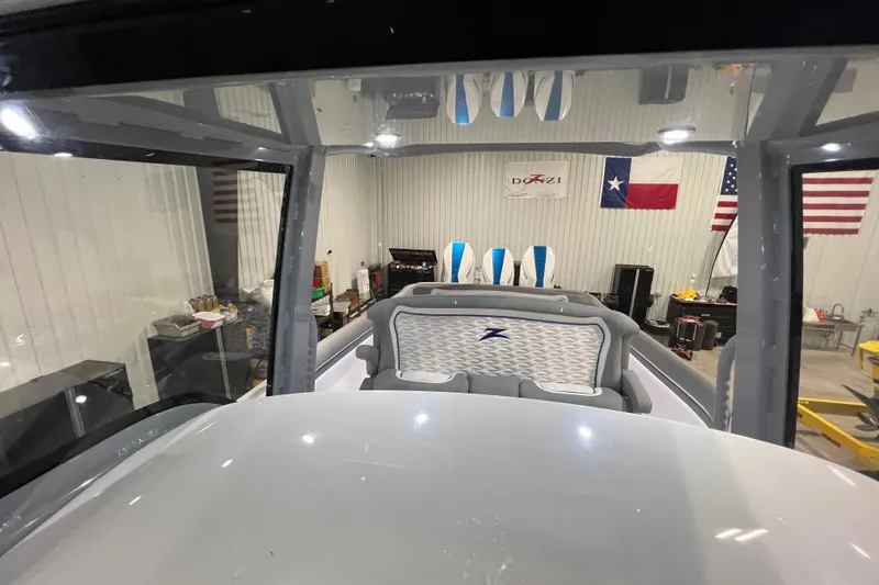 Slide: The Image of 2024 Donzi 39 VRZ boat interior with modern dashboard and seating in a showroom. - 61