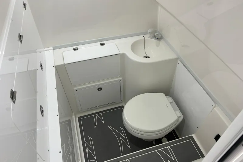 Slide: The Image of Interior view of 2024 Donzi 39 VRZ boat in a workshop with flags displayed. - 64