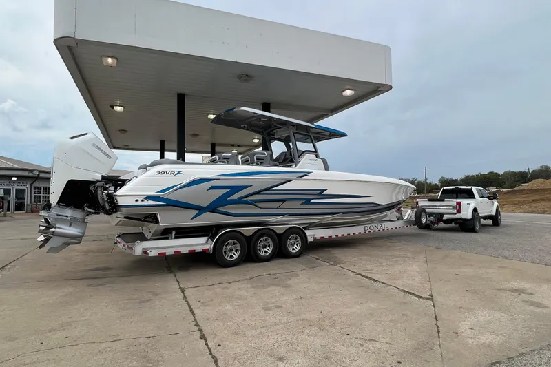 Slide: The Image of 2024 Donzi 39 VRZ boat on trailer at gas station, side view. - 71
