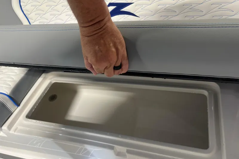 Slide: The Image of Hand opening storage compartment on 2024 Donzi 39 VRZ boat seat. - 74