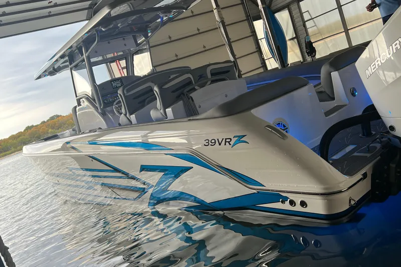 Slide: The Image of 2024 Donzi 39 VRZ boat with sleek design and blue accents in a marina setting. - 77