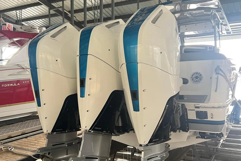 Slide: The Image of 2024 Donzi 39 VRZ boat with triple outboard engines in a marina setting. - 81