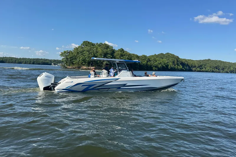 Slide: The Image of 2024 Donzi 39 VRZ boat cruising on a lake under a clear blue sky. - 83