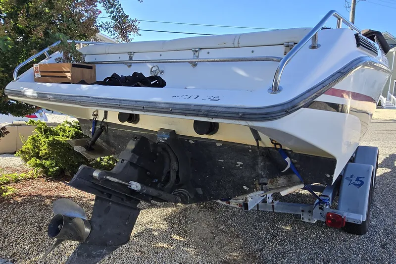 Slide: The Image of 1990 Baja 250 ES boat on trailer, rear view with visible propeller and railing. - 11