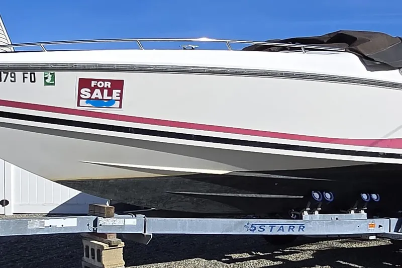 Slide: The Image of 1990 Baja 250 ES boat interior with white and red seating, wooden plank, and metal rod. - 13