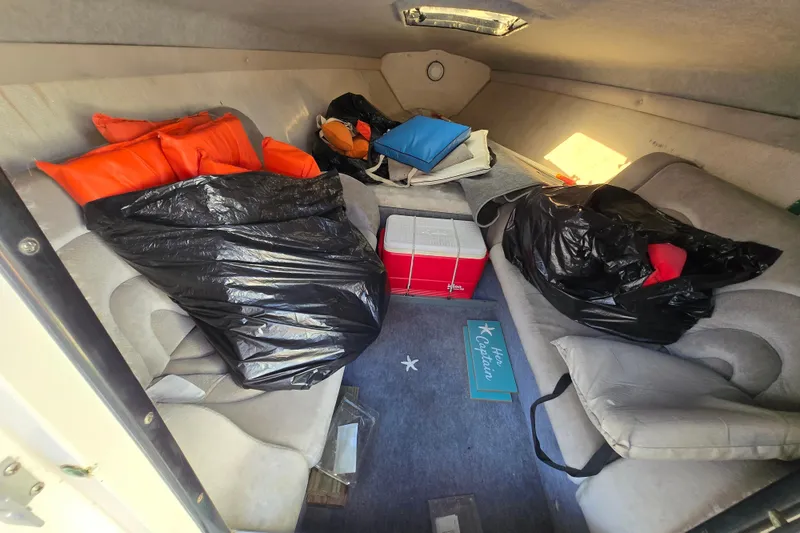 Slide: The Image of Interior of a 1990 Baja 250 ES boat with cushions, bags, and a cooler. - 8