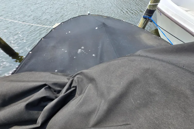 Slide: The Image of 2012 Bayliner 190 Bowrider with black cover docked on water. - 13