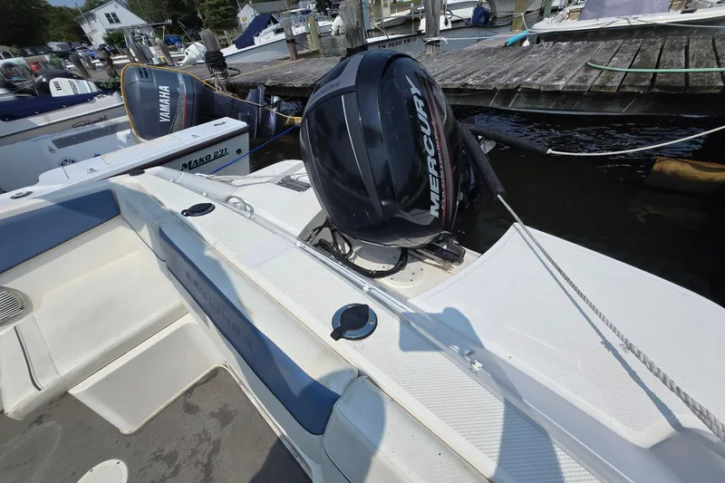 Slide: The Image of 2012 Bayliner 190 Bowrider with Mercury outboard engine docked at marina. - 14