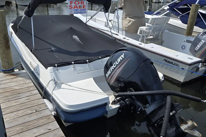 Slide: The Image of 2012 Bayliner 190 Bowrider with Mercury outboard engine, docked and covered, for sale. - 17