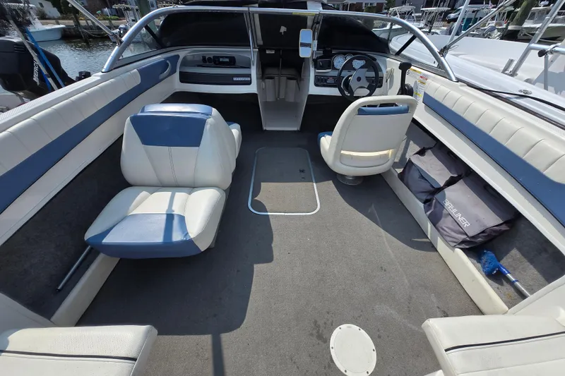 Slide: The Image of 2012 Bayliner 190 Bowrider interior with blue and white seating, spacious layout. - 4
