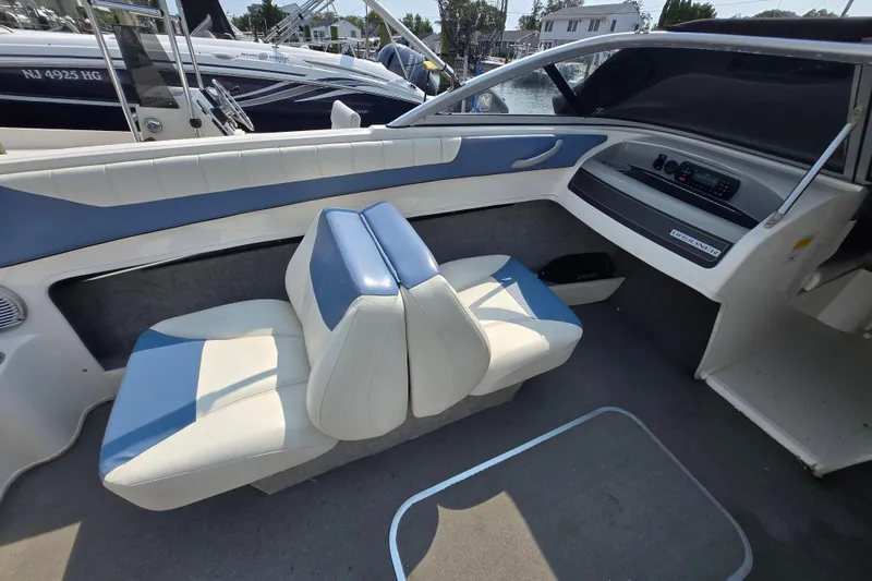 Slide: The Image of Interior of 2012 Bayliner 190 Bowrider boat with blue and white seating. - 8