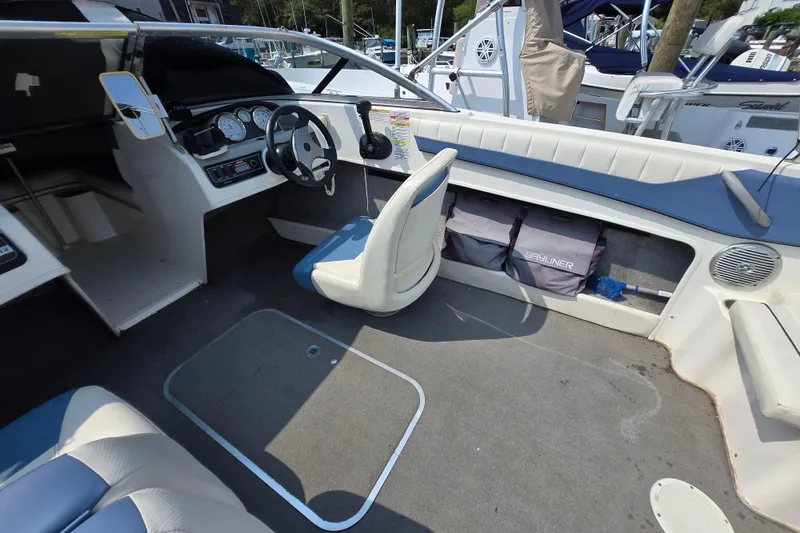 Slide: The Image of 2012 Bayliner 190 Bowrider interior with steering wheel, seating, and storage compartments. - 9