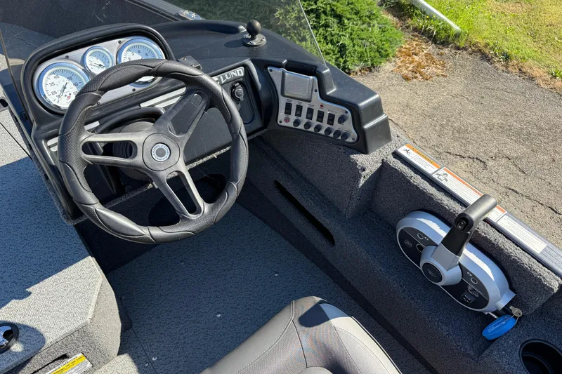 Slide: The Image of 2021 Lund 1675 Adventure Sport boat dashboard with steering wheel and control panel. - 7