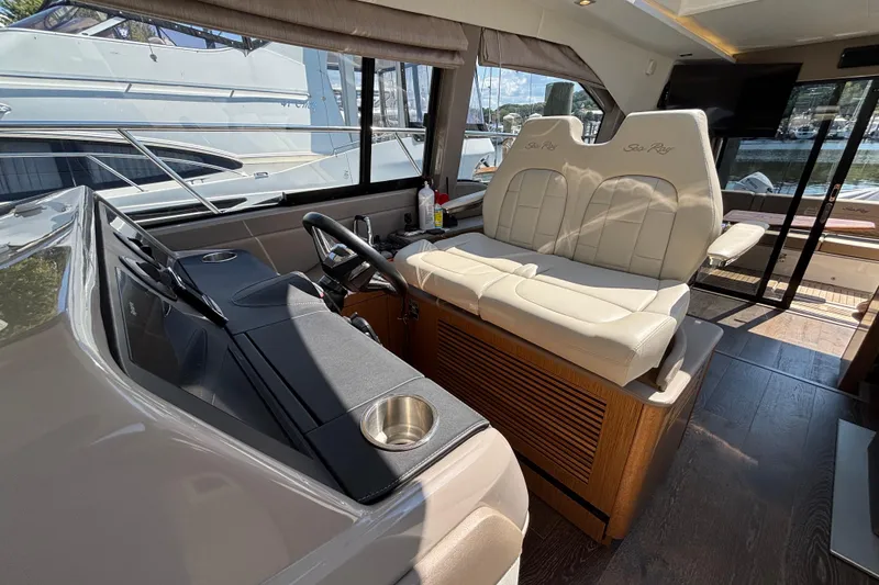 Slide: The Image of 2018 Sea Ray Sundancer 460 yacht interior with helm and plush seating. - 18