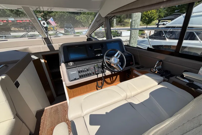 Slide: The Image of Interior of 2018 Sea Ray Sundancer 460 yacht, featuring helm with modern controls and leather seating. - 19