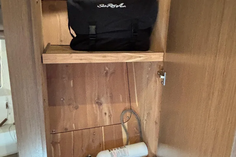 Slide: The Image of Wooden cabinet interior with a Sea Ray bag and a fire extinguisher, 2018 Sea Ray Sundancer 460. - 29