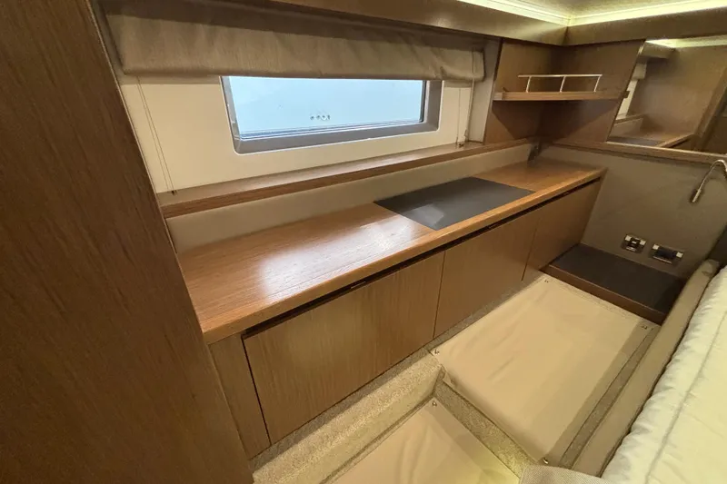 Slide: The Image of 2018 Sea Ray Sundancer 460 interior with wooden cabinetry and window view. - 36