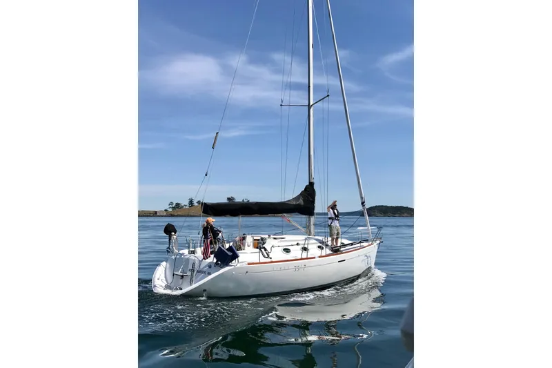 Slide: The Image of 1994 Beneteau First 35s-7 sailboat on calm water under clear blue sky. - 1