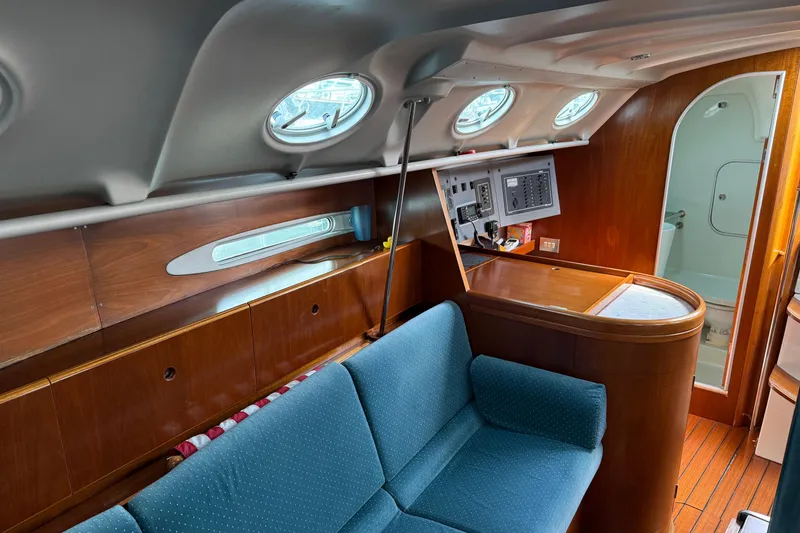 Slide: The Image of Interior of 1994 Beneteau First 35s-7 yacht with wood paneling and blue seating. - 10