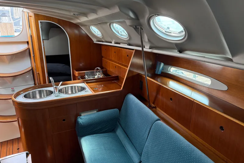 Slide: The Image of Interior of 1994 Beneteau First 35s-7 yacht with wooden cabinetry and blue seating. - 17