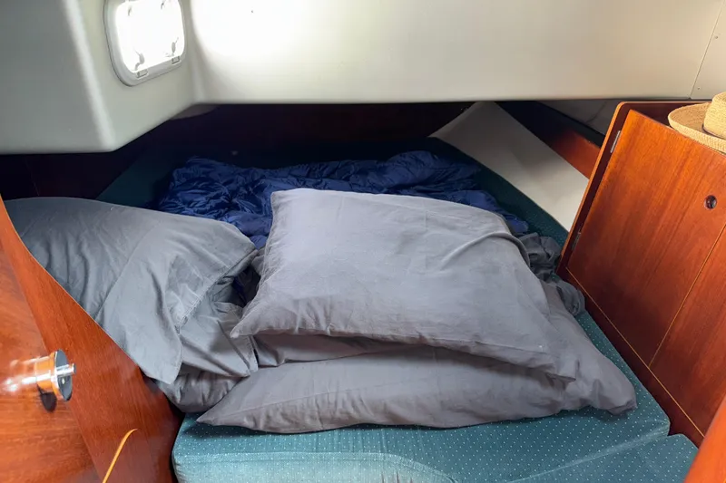Slide: The Image of Cozy cabin interior of 1994 Beneteau First 35s-7 sailboat with bedding and wooden cabinetry. - 21