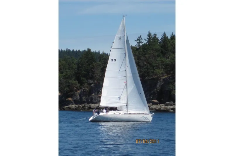 Slide: The Image of 1994 Beneteau First 35s-7 sailboat on calm water near forested shoreline. - 3