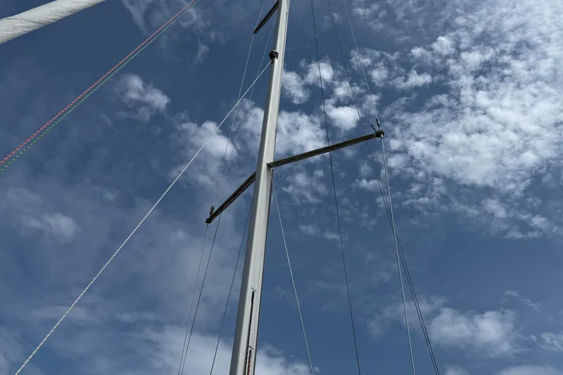 Slide: The Image of Mast of 1994 Beneteau First 35s-7 sailboat against a cloudy blue sky. - 8
