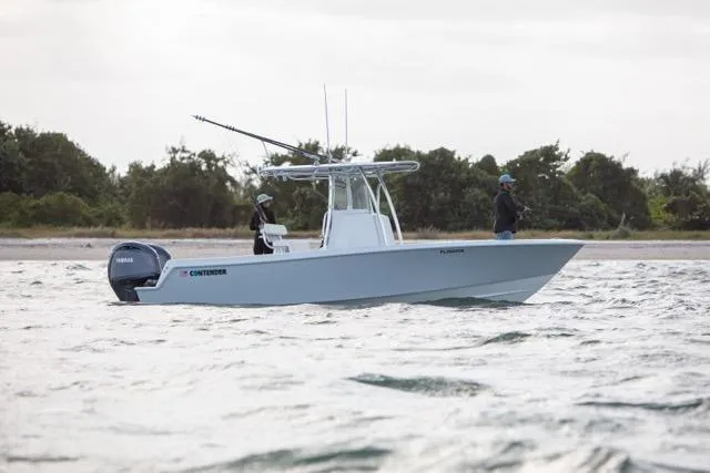 Slide: The Image of 2025 Contender 25 Tournament boat on water, two people fishing, Yamaha engine, coastal background. - 1