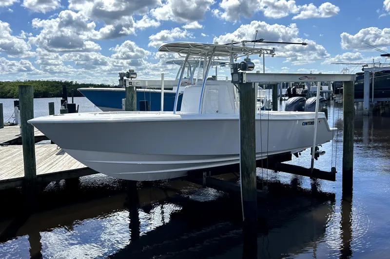 Slide: The Image of 2025 Contender 25 Tournament boat docked under a cloudy sky. - 13