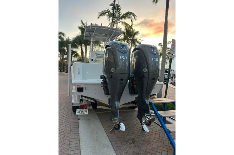 Slide: The Image of 2025 Contender 25 Tournament boat with dual Yamaha 150 engines, parked near palm trees. - 19