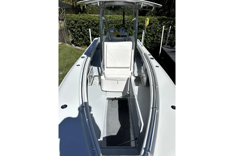 Slide: The Image of 2025 Contender 25 Tournament boat interior with seating and console, surrounded by greenery. - 3