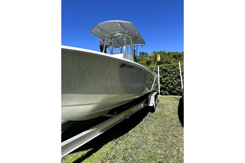 Slide: The Image of 2025 Contender 25 Tournament boat on trailer, sunny day, grassy area. - 4