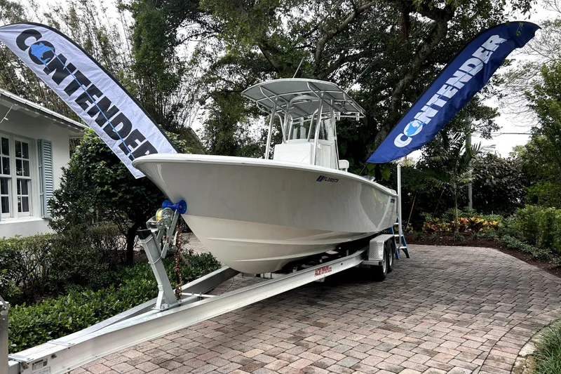 Slide: The Image of 2025 Contender 25 Tournament boat on trailer, displayed outdoors with branded flags. - 5