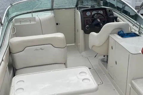 Slide: The Image of 2008 Sea Ray 290 Sundeck interior with seating and helm, docked by water. - 3