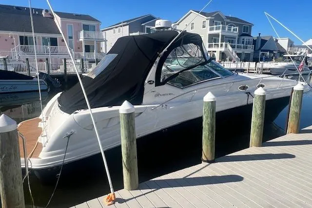 The Image of 2008 Sea Ray 340 Sundancer docked at a marina with waterfront homes in the background. - 0