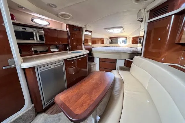 Slide: The Image of 2008 Sea Ray 340 Sundancer interior with kitchenette, seating, and bed. Luxurious yacht cabin design. - 13