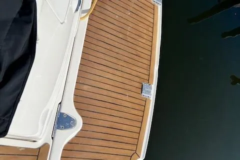 Slide: The Image of 2008 Sea Ray 340 Sundancer boat deck with wood finish by the water. - 21